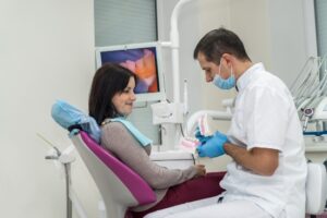 Doctor Showing Patient Root Canal Aftercare in Parker, CO