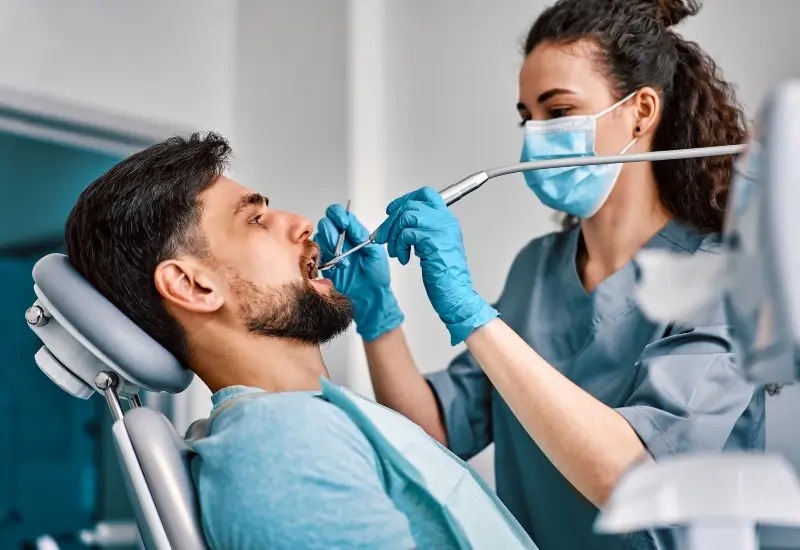 A patient getting his teeth cleaned before getting a dental implant in Parker, CO